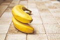 Two ripe bananas on a checkered wooden surface