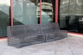 Long curving metal bench for folks to sit on outside building