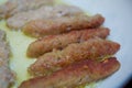 The long cutlet is fried in a red pan. She cooks the cutlet in a white pan . Juicy homemade cutlets beef, pork, chicken Royalty Free Stock Photo