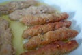 The long cutlet is fried in a red pan. She cooks the cutlet in a white pan . Juicy homemade cutlets beef, pork, chicken Royalty Free Stock Photo