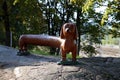 Long dachshund shaped brown bench located in a dog park in Helsinki, Finland