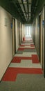 Long dark corridor in a hotel. Straight lines and perspective in a bright window. Royalty Free Stock Photo