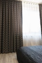 Long dark luxury curtains and tulle curtains, sheers on a window in the bedroom. Interior design concept