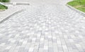 A long descent covered with gray paving slabs. The ramp is paved with concrete tiles. Wheelchair and bicycle accessibility concept