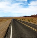 Long desert highway leading into Death Valley National Park, USA Royalty Free Stock Photo