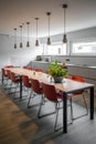 Long dining table with red chairs in an office building