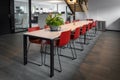 Long dining table with red chairs in an office building