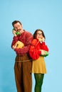 Portrait with happy couple handsome man and beautiful woman talking via telephones and smiling over blue background