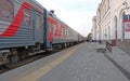 Long-distance train standing on a platform next to the station building Royalty Free Stock Photo