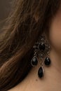 earrings with dark stones hang on the girl's ear Royalty Free Stock Photo