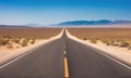 A long, empty road stretches through the desert towards distant mountains Royalty Free Stock Photo