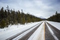 Long empty winter road leading to mountains, Banff national park, Canada