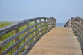 long and empty wooden foot path bridge over the marsh and water to the ocean beach Royalty Free Stock Photo