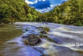 A long exposure across rapids on the river Teifi at Cenarth, Wales after heavy rainfall