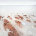 Long exposure artistic landscape, sea and red stones Royalty Free Stock Photo
