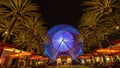 Long Exposure of the blue illuminated Ferris wheel at the Irvine Spectrum between palms