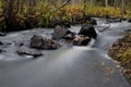 Long exposure, blurry water effect. Atmospheric forest landscape with rapids on powerful mountain river between rocks Royalty Free Stock Photo