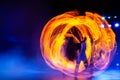 Fire Dancer Surrounded By  Swirling Flames And Vibrant Light Trails In Night Stage Performance. Copy Space. Long Exposure Photo. Royalty Free Stock Photo