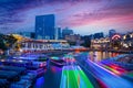 Long exposure of colorful boats moving on Singapore River during sunset blue hour