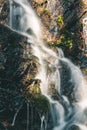 Long exposure creamy waterfall on small forest brook from thawing snow shined by sunset sun. Czech republic Royalty Free Stock Photo