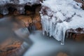 Long exposure creek water flowing with frozen dripping water, natural winter Royalty Free Stock Photo