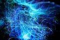 Long exposure of fiber optical light cables in LED neon blue glow. Optics with spiral motion effects for fast data Royalty Free Stock Photo