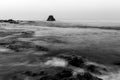 Long exposure fluffy ocean mists rush over tidal pool rocks at the beach Royalty Free Stock Photo