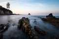 Long exposure fluffy ocean mists rush over tidal pool rocks at the beach Royalty Free Stock Photo