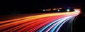 A long-exposure image of light trails from moving vehicles at night, creating a sense of motion and excitement. Web banner