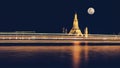 Wat arun pagoda on Chao Phraya river bank at night with fullmoon and light trail