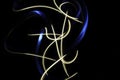 Long exposure light painting photography, curvy lines and vibrant metallic neon white and blue against a black background.