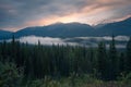 Long exposure of mist rolling through the valley in Banff National Park in the early morning. Blue hour with sparse sunlight in Royalty Free Stock Photo