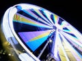 Long exposure motion blur of a spinning ferris wheel at night illuminated in bright neon colors Royalty Free Stock Photo