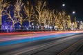 Long exposure night city light festive street urban view colorful illumination from fuzzy cars headlights and garlands on trees