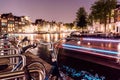 Long Exposure Night city view of Amsterdam with Light trails of Boat in channel and typical dutch houses on background Royalty Free Stock Photo