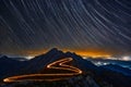 Long-exposure night photography of a starry sky over a mountain range, with light trails Royalty Free Stock Photo