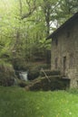 Long exposure of an old French mill house in the forest with a small waterfall. Royalty Free Stock Photo