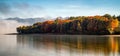 Long exposure photo of colorful autumn leaves on trees on coast of lake Royalty Free Stock Photo