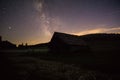 Purple night sky stars over mountain and old wooden house. Milky way galaxy in summer starry night Royalty Free Stock Photo