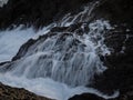 Long exposure of rough whitewater ocean sea wave flowing down cliff rock cascade natural power splash in Galicia Spain