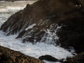 Long exposure of rough whitewater ocean sea wave flowing down cliff rock cascade natural power splash in Galicia Spain