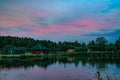 Long exposure scenic view of small red house on the bank of still pond Royalty Free Stock Photo