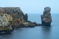 Long exposure seascape of the cliffs of Papoa island in Carvoeiro cape from the sea at sunrise in a cloudy day, Atlantic coast, Royalty Free Stock Photo