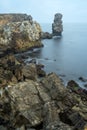 Long exposure seascape of the cliffs of Papoa island in Carvoeiro cape from the sea at sunrise in a cloudy day, Atlantic coast, Royalty Free Stock Photo