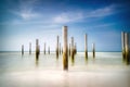 Long exposure seascape. Taken at the North Sea in Petten with the pole village in the sea, Blue sky, sun and shodows