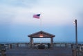 A long exposure of a shelter at the end of a pier with an American flag. Royalty Free Stock Photo