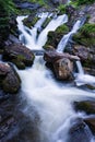 Long exposure shot of a beautiful waterfall flowing down the mossy rocks in vertical Royalty Free Stock Photo