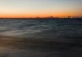 Long exposure shot of dark sea with ships pier