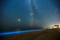 Long exposure shot of glowing plankton on sea surf and milky way. Blue bioluminescent glow of water under the starry sky Royalty Free Stock Photo