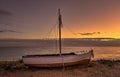 A Long exposure shot of a Greek stranded fishing boat on the beach during sunset.